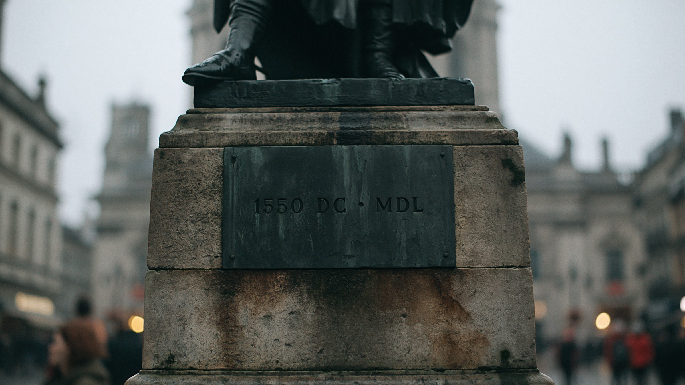 Detalhe da plaquinha de bronze no pedestal da estátua: 1550 DC · MDL.